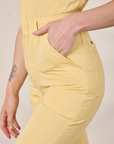 Side close up of Alex's hand in the pocket of Short Sleeve Jumpsuit in Butter Yellow