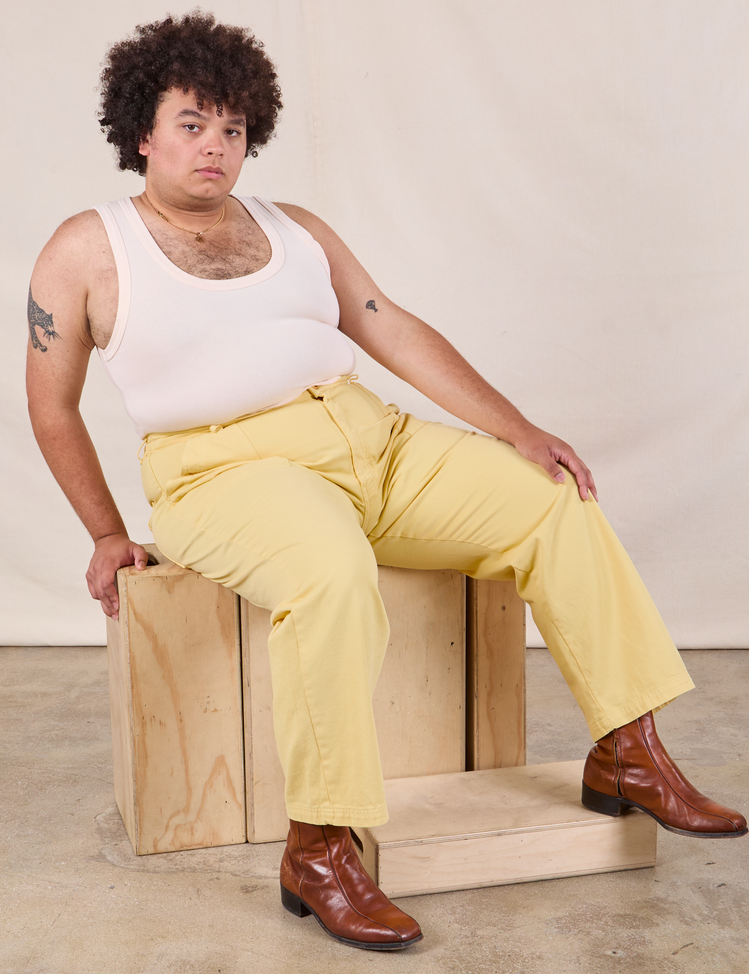 Miguel is wearing Work Pants in Butter Yellow and Tank Top in vintage tee off-white
