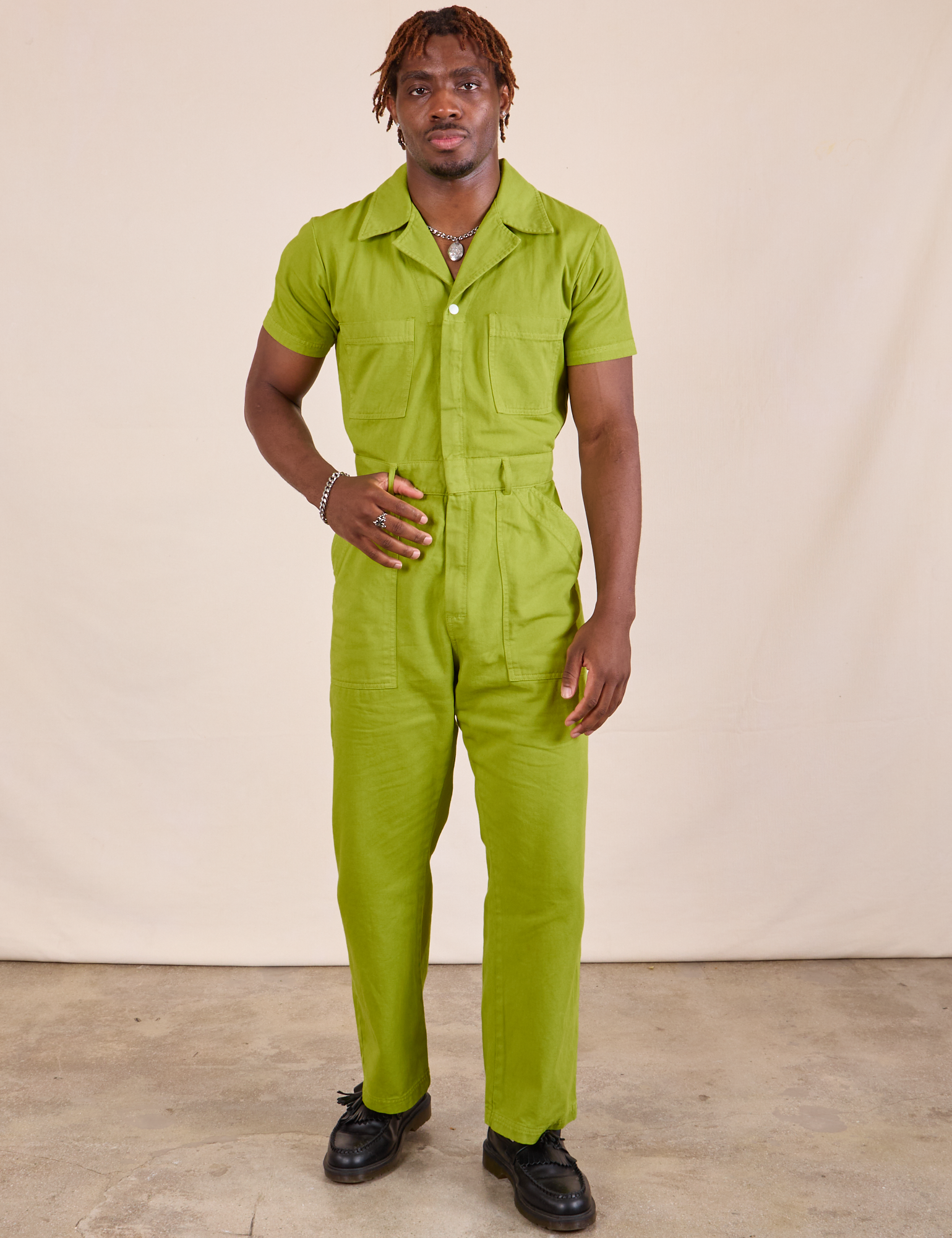 Issac is 5'10" and wearing M Short Sleeve Jumpsuit in Gross Green