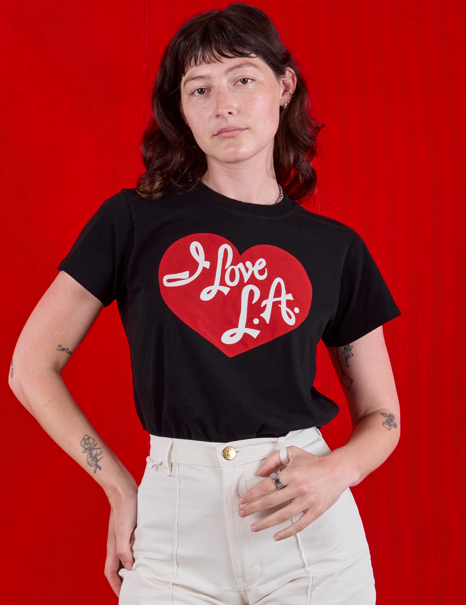 Alex is wearing  I love LA Tourist Tee tucked in vintage tee off-white Western Pants