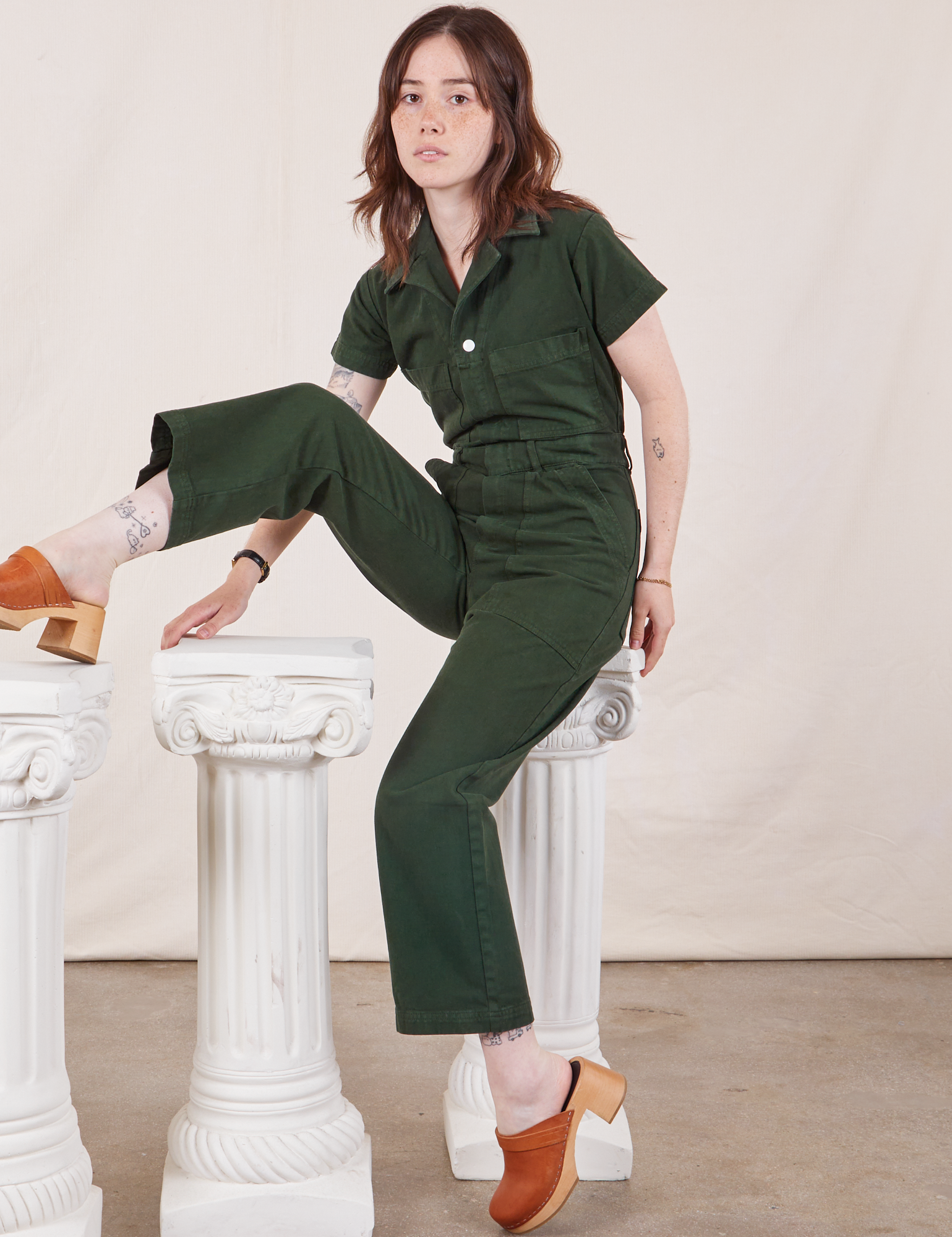 Hana is wearing Petite Short Sleeve Jumpsuit in Swamp Green