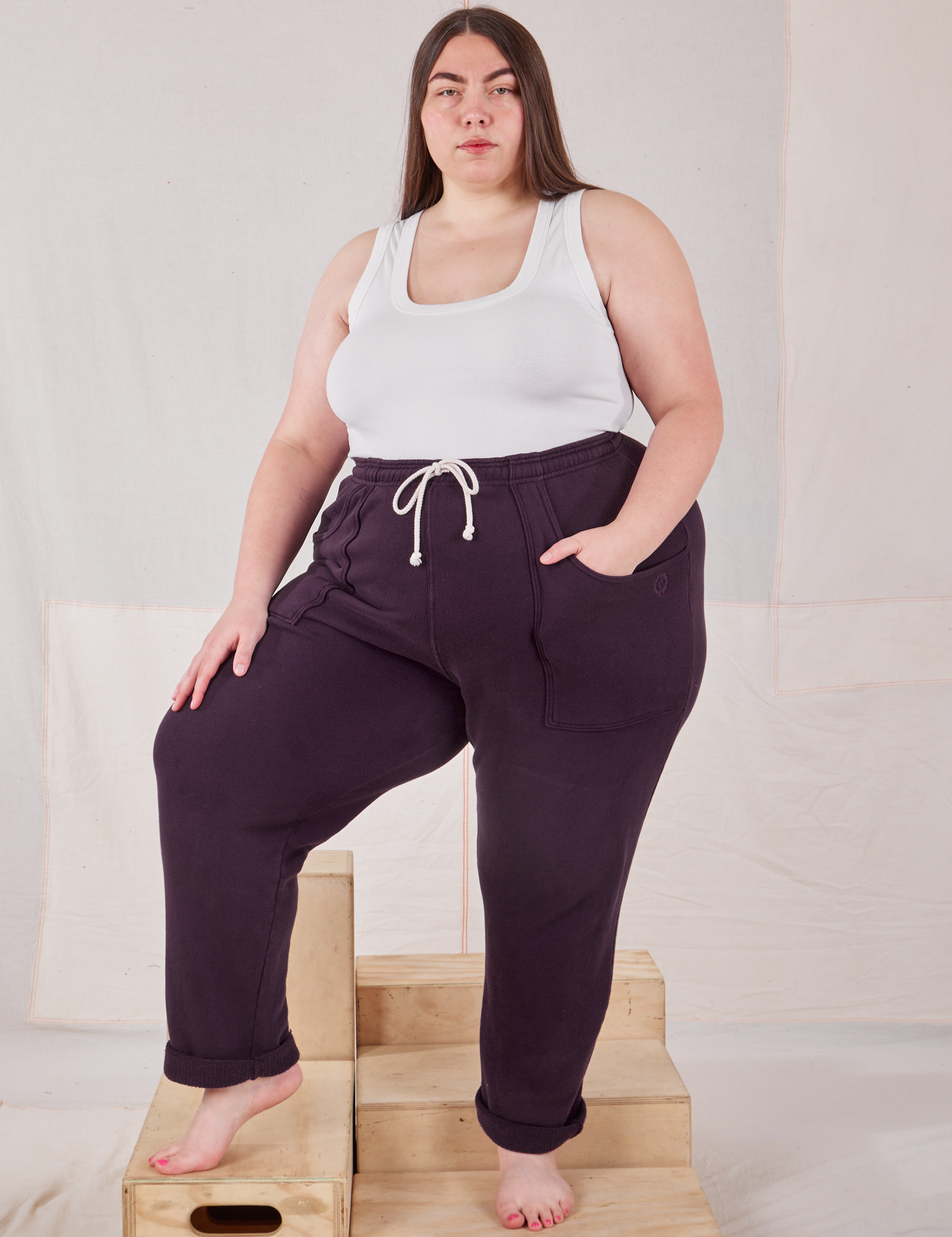 Marielena is 5&#39;8&quot; and wearing 1XL Rolled Cuff Sweat Pants in Nebula Purple paired with Cropped Tank in vintage tee off-white