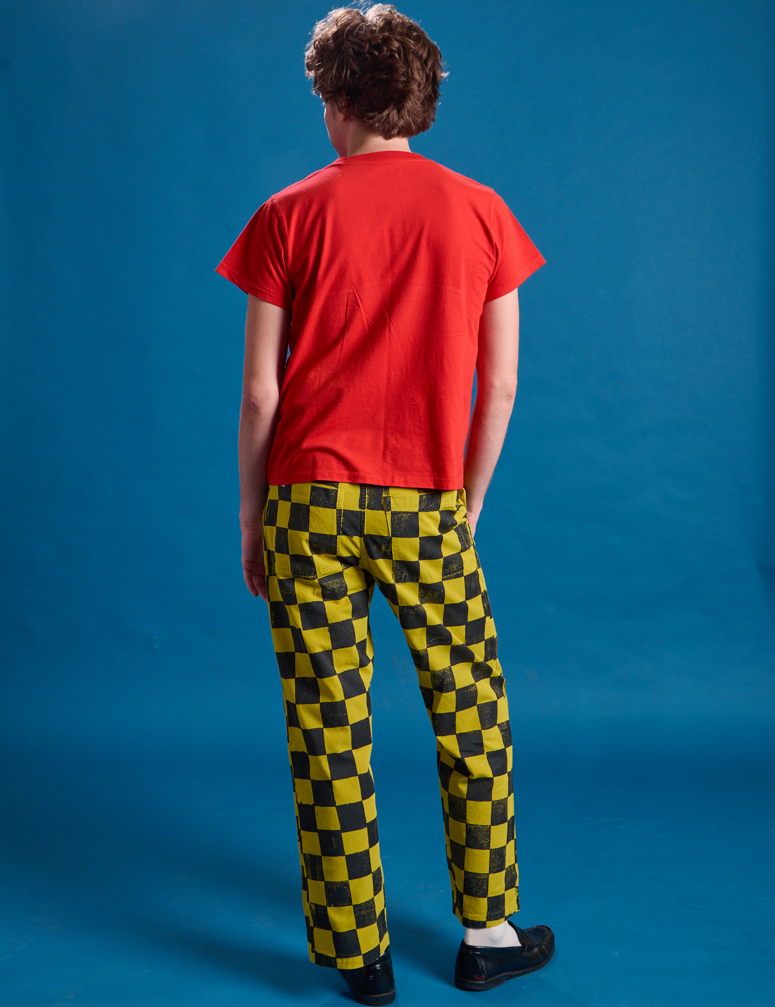 Back view of Checkerboard Work Pants in Yellow/Black and mustang red Organic Vintage Tee on Quinn