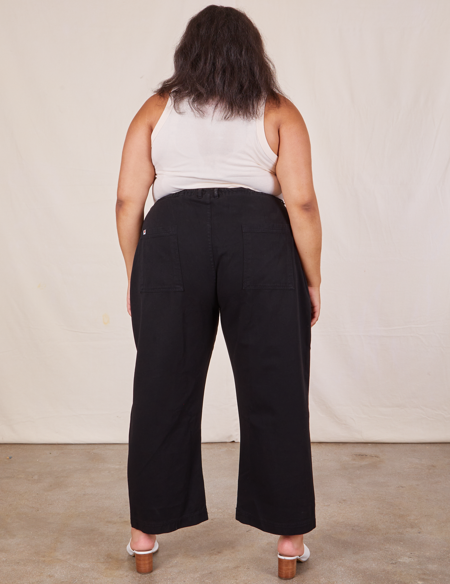 Back view of Western Pants in Basic Black and Tank Top in vintage tee off-whiteworn by Alicia