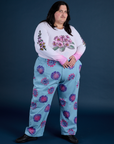 Sam is wearing Floral Painted Work Pants in Blue and Floral Long Sleeve Baby Tee in pink