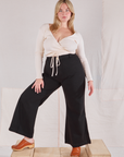 Lish is wearing Wrap Top in Vintage Tee Off-White and black Bell Bottoms
