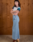 Side view of Calypso Tee in Ocean and light wash Indigo Wide Leg Trousers on Alex