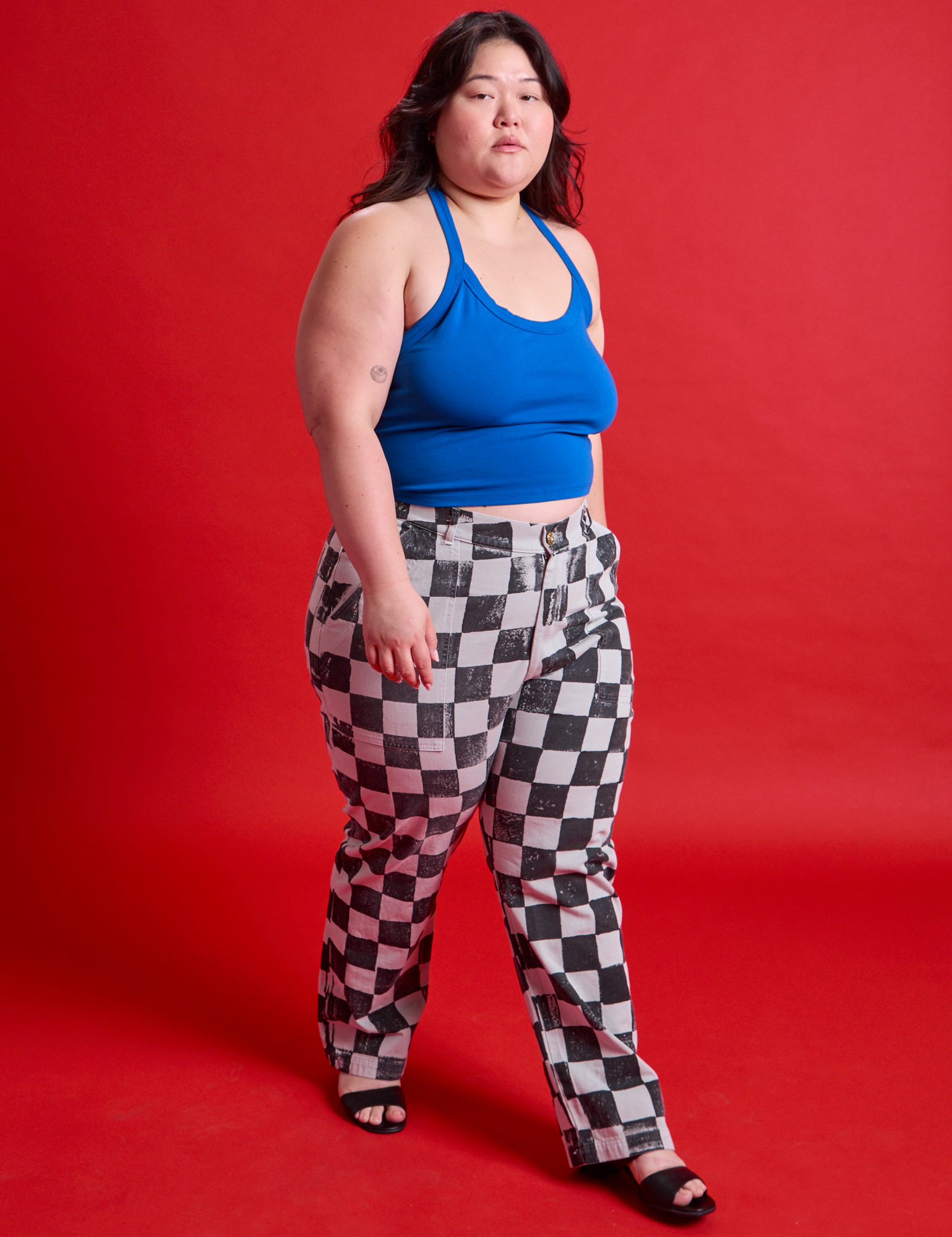 Ashley is 5'7" and wearing 1XL Checkerboard Work Pants in Black/White paired with a royal blue Halter Top