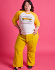 Ashley is wearing Taxi Raglan Tee in Toronto paired with golden yellow Western Pants