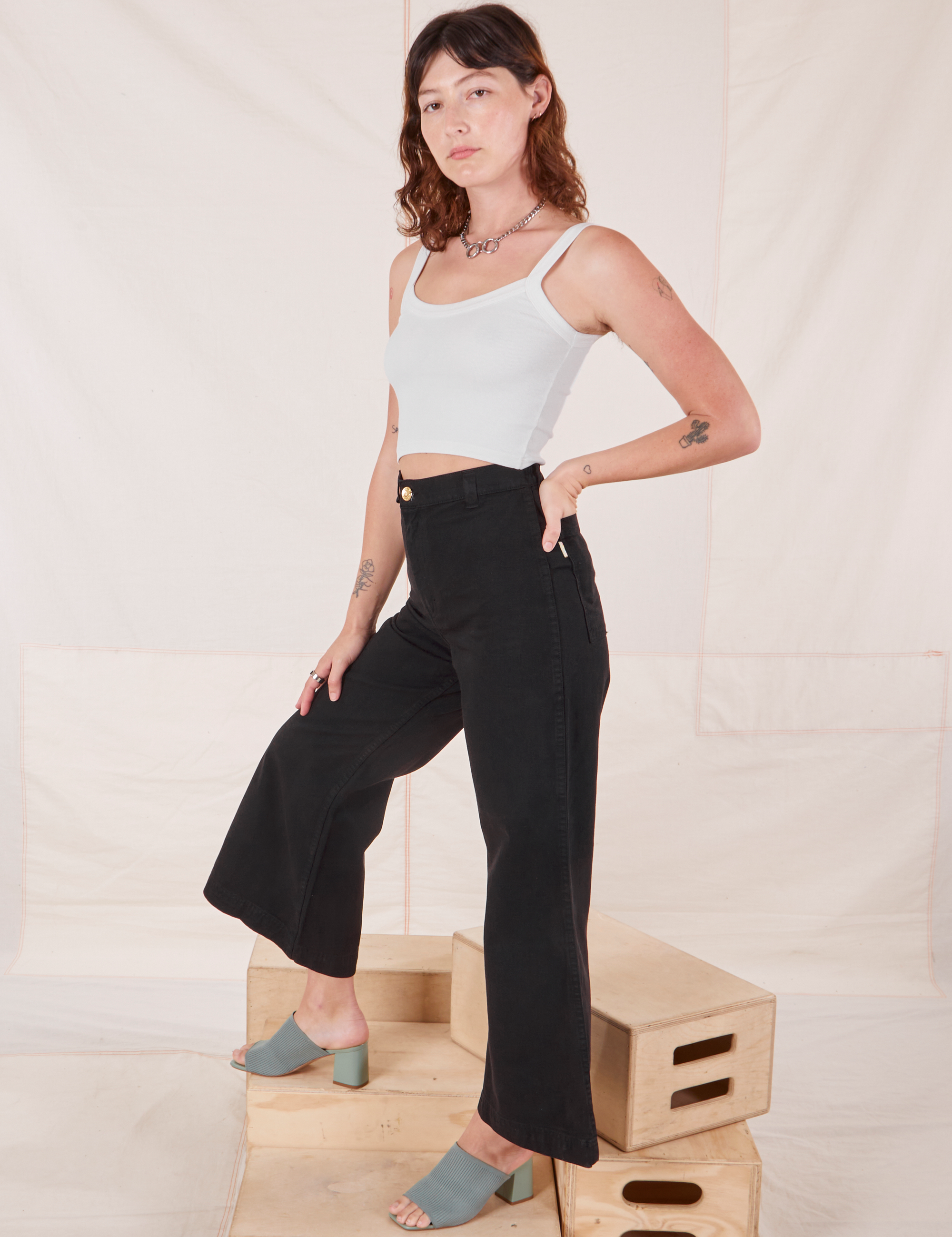 Side view of Bell Bottoms in Basic Black and Cropped Cami in vintage tee off-white on Alex
