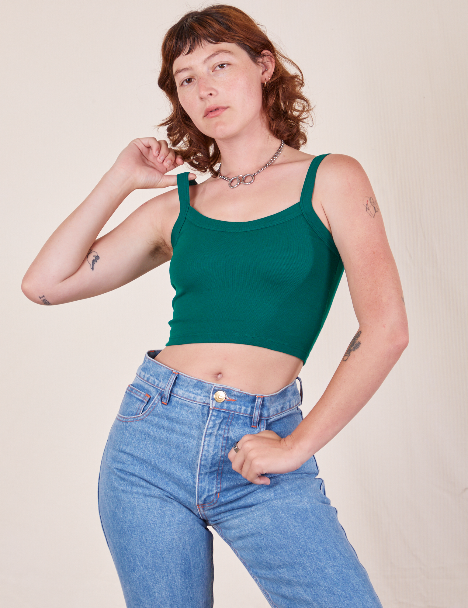 Alex is 5&#39;8&quot; and wearing P Cropped Cami in Hunter Green paired with light wash Frontier Jeans