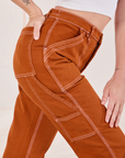 Carpenter Jeans in Burnt Terracotta side close up on Alex