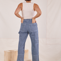 Back view of Carpenter Jeans in Railroad Stripes. Tiara has both her hands in the back pockets.
