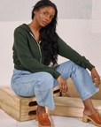 Kandia is wearing Cropped Zip Hoodie in Swamp Green and light wash Carpenter Jeans