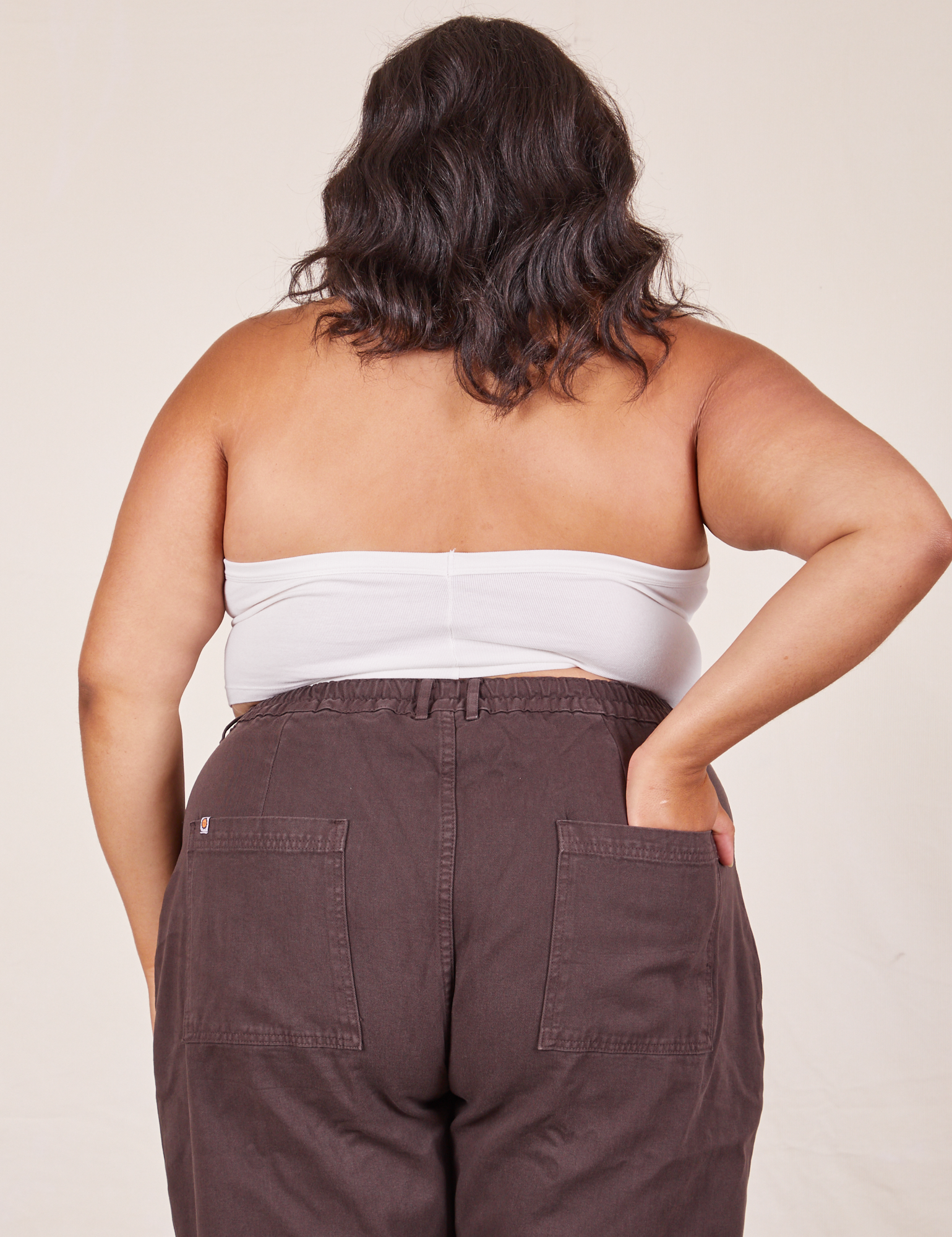 Back view of Halter Top in Vintage Tee Off-White and espresso brown Western Pants worn by Alicia. She has her left hand in the back of the pant pocket.