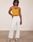 Jerrod is 6'3" and wearing XS Halter Top in Mustard Yellow paired with vintage off-white Western Pants