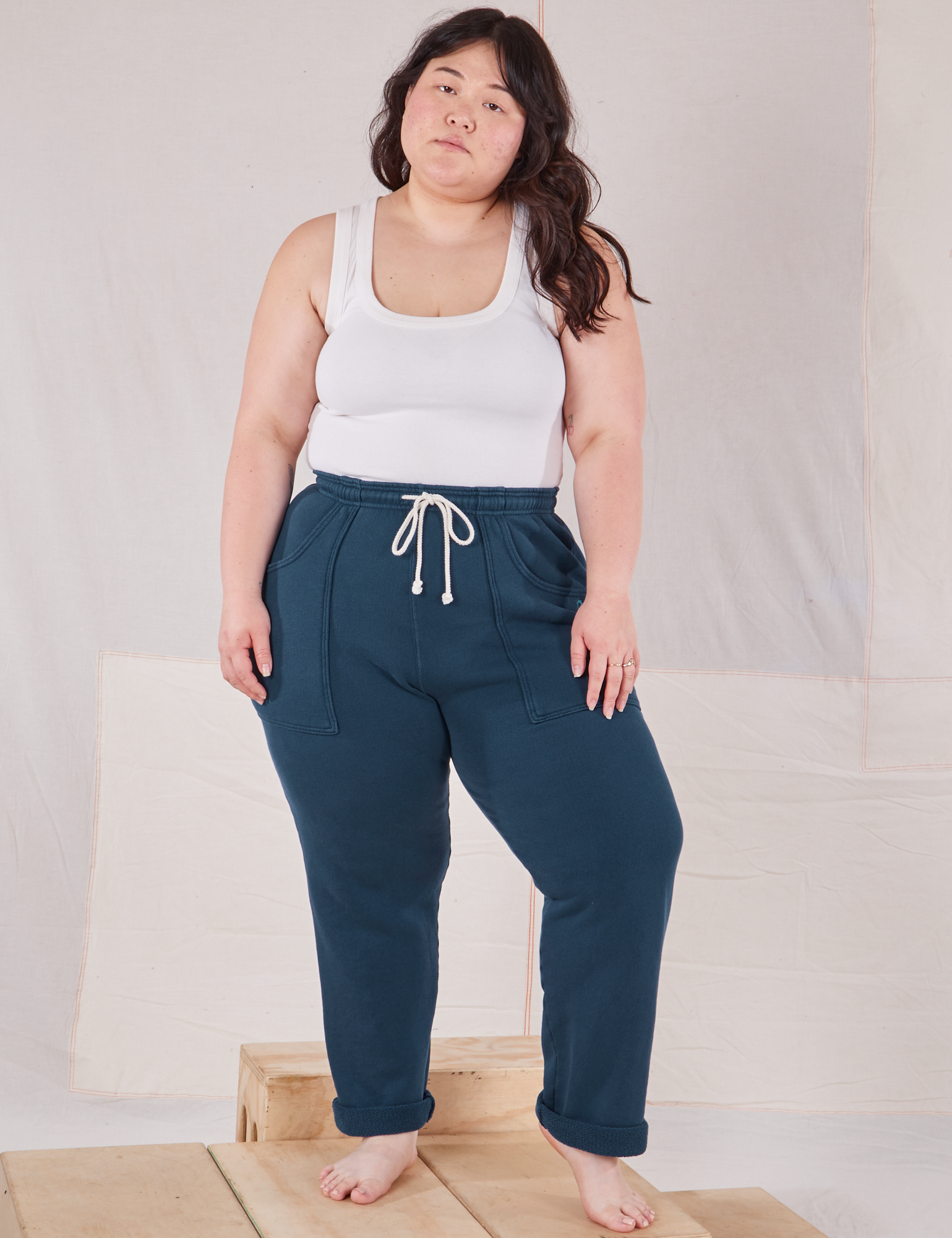 Ashley is 5&#39;7&quot; and wearing L Rolled Cuff Sweat Pants in Lagoon paired with Cropped Tank in vintage tee off-white