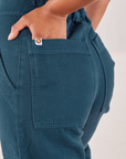 Heritage Short Sleeve Jumpsuit in Lagoon back pocket close up. Mika has her hand in the pocket.