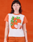 Alex is 5’8” and wearing P Anniversary Tee in Orange Blossom