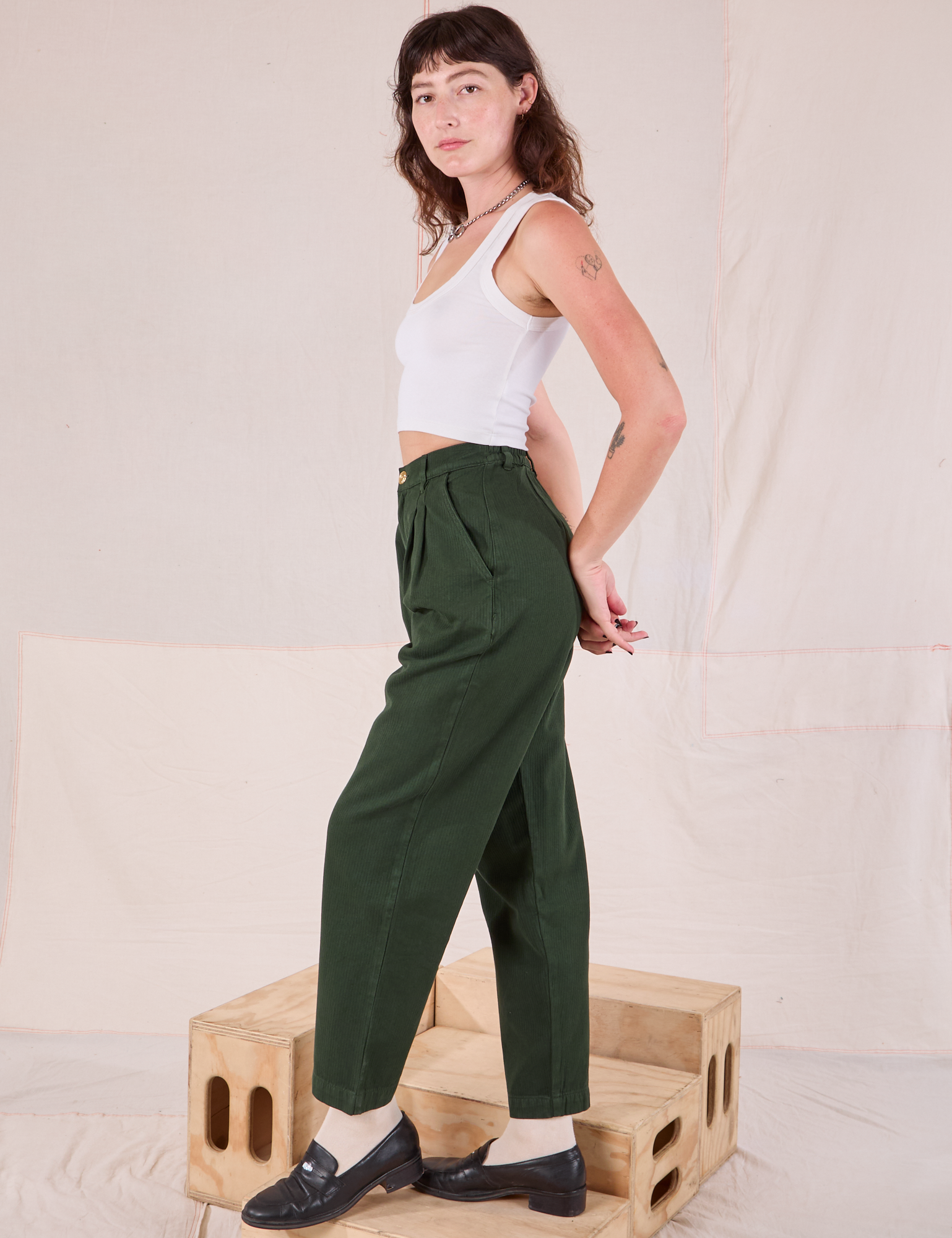 Side view of Heritage Trousers in Swamp Green and Cropped Tank in vintage tee off-white on Alex