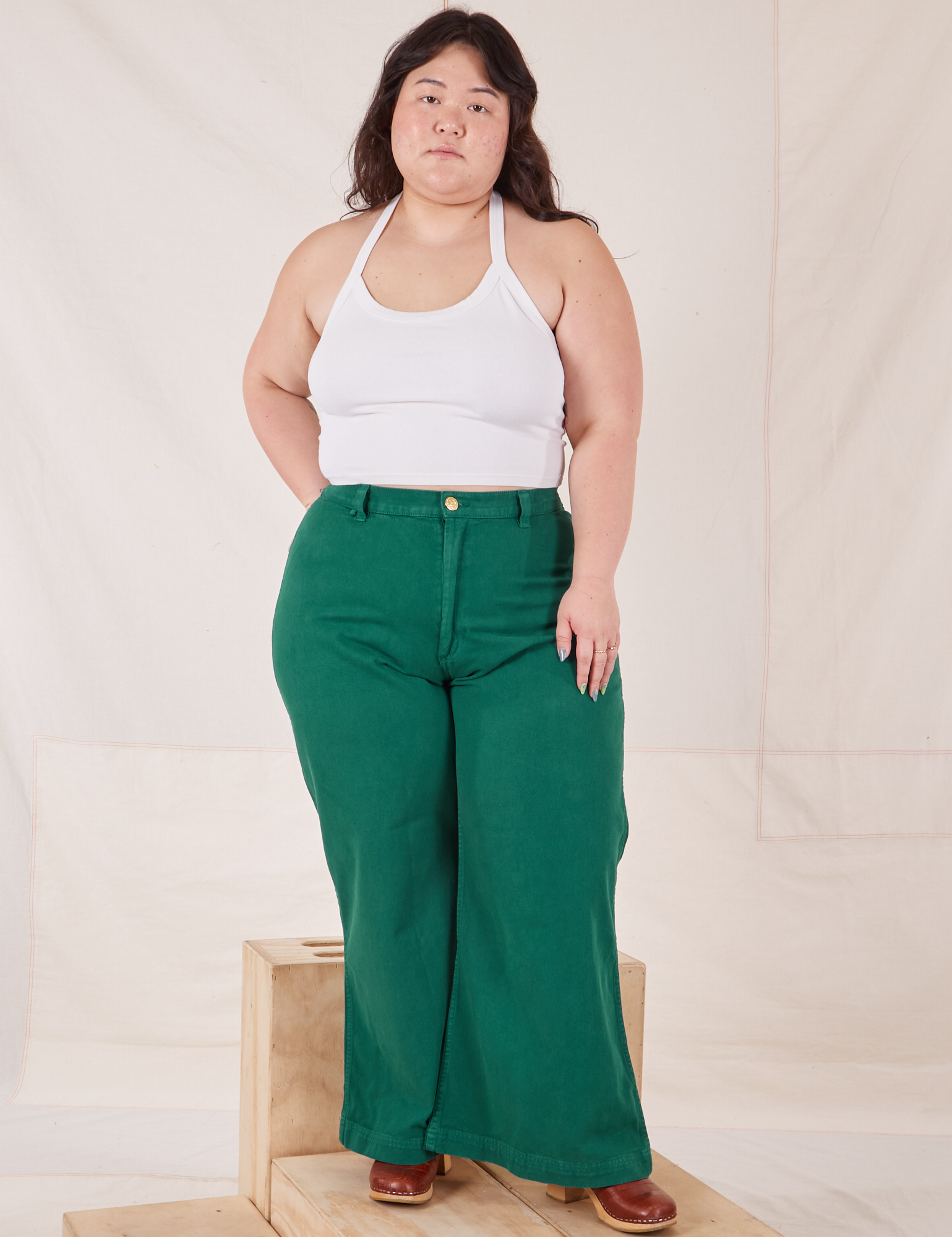 Ashley is 5&#39;7&quot; and wearing 1XL Bell Bottoms in Hunter Green paired with vintage off-white Halter Top
