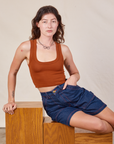 Alex is wearing Carpenter Shorts in Dark Wash and burnt terracotta Cropped Tank