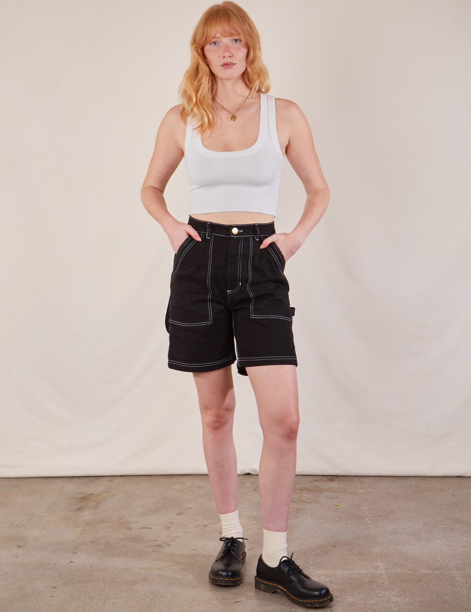 Margaret is 5'11" and wearing XS Carpenter Shorts in Basic Black paired with a Cropped Tank in vintage tee off-white