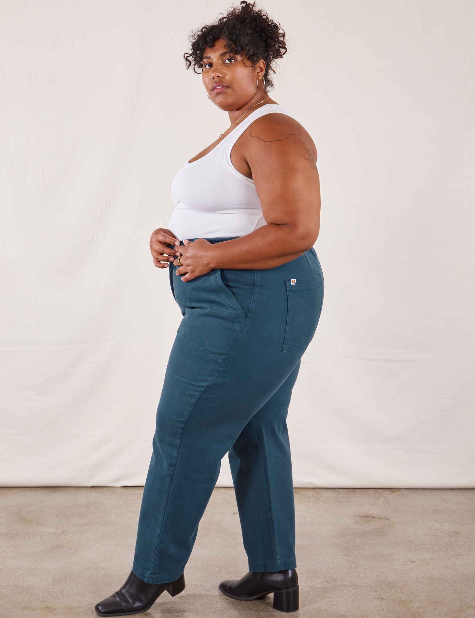 Side view of Work Pants in Lagoon and vintage tee off-white Tank Top