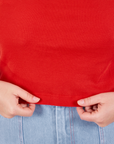 Muscle Tee in Mustang Red worn by Lish holding the hem
