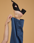 Alex is pulling on the hem of the Baggy Mid-Rise Trousers in French Blue
