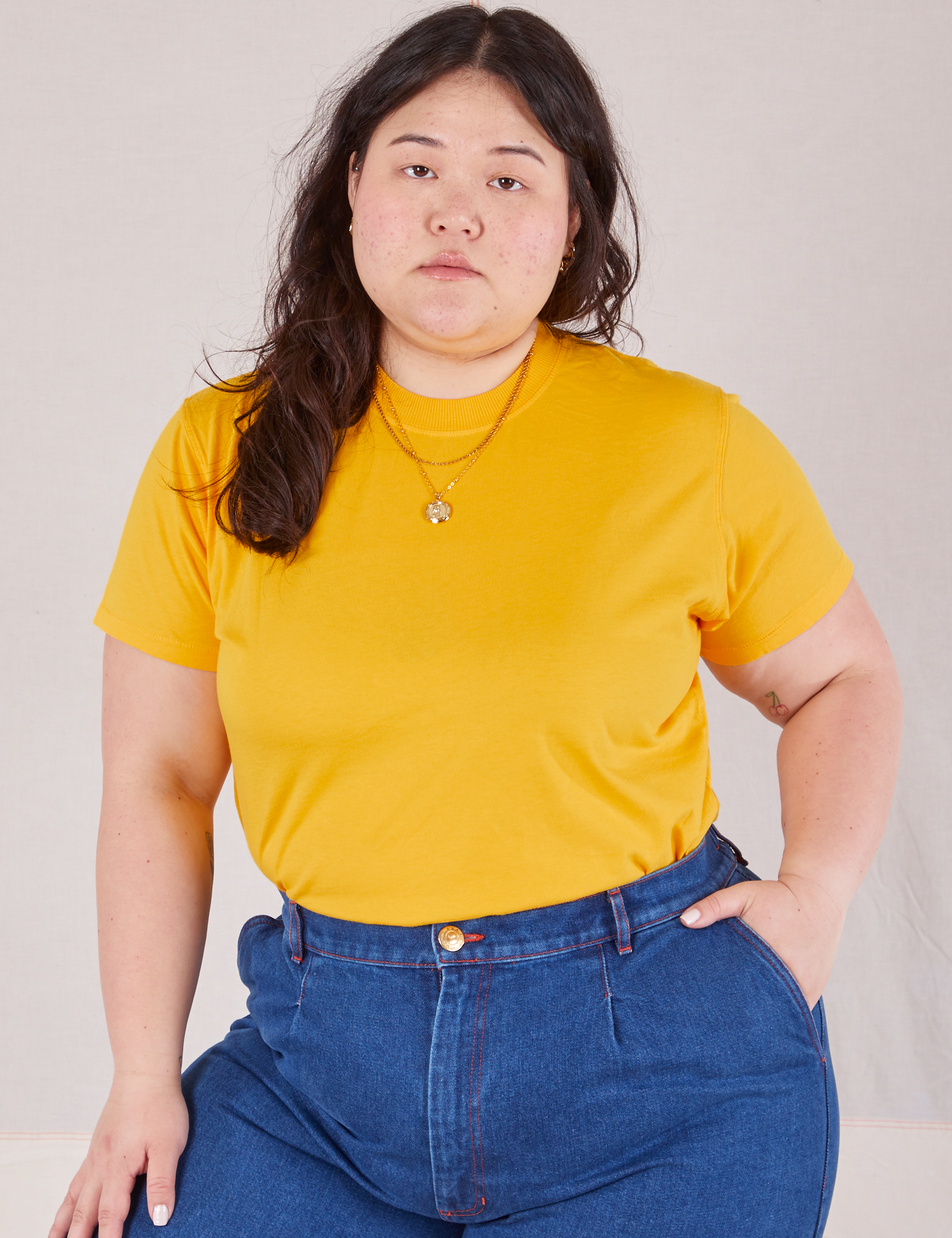 Ashley is 5'7" and wearing L Organic Vintage Tee in Sunshine Yellow tucked into dark wash Trouser Jeans