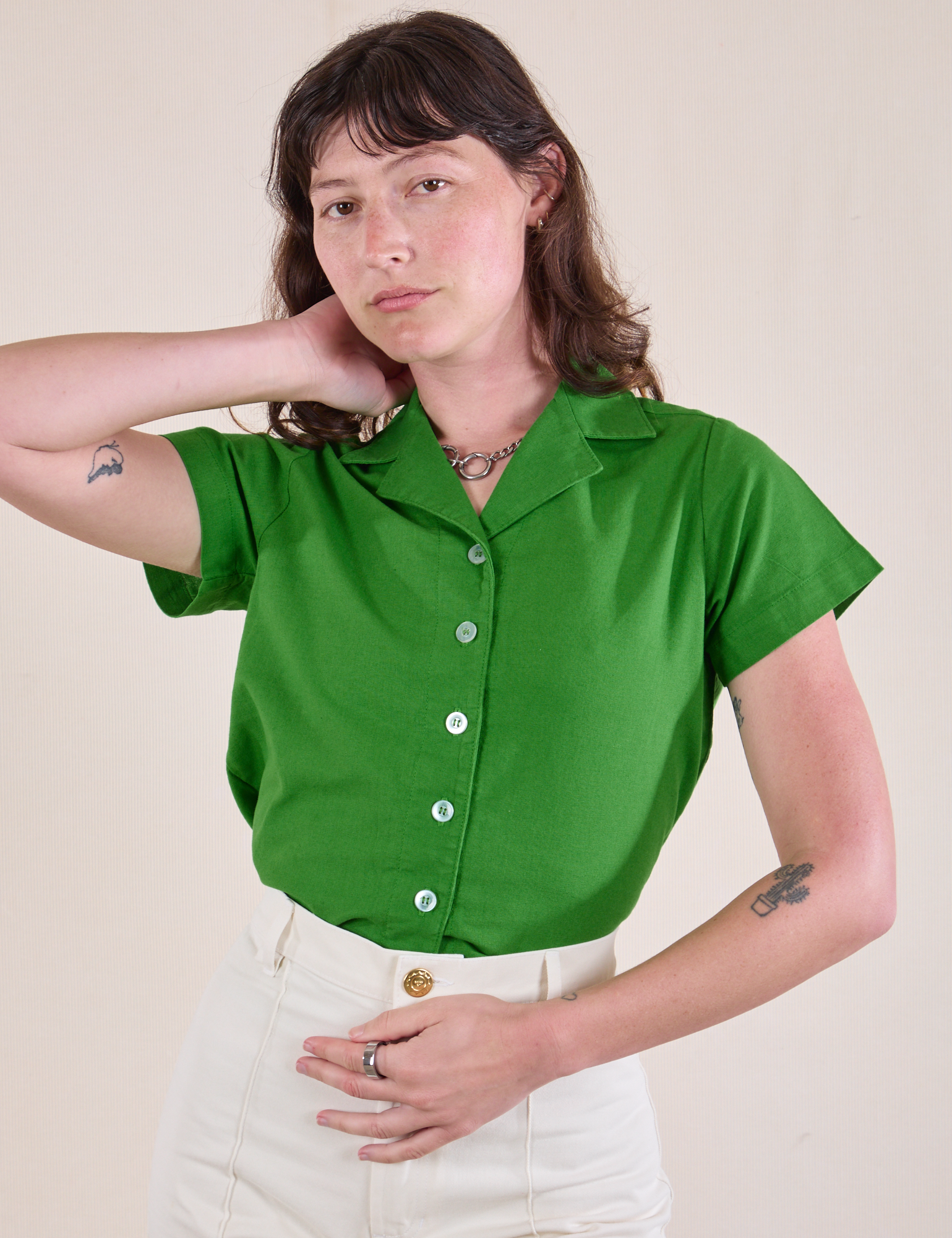 Alex is wearing a Pantry Button-Up in Kelly Green tucked into vintage tee off-white Western Pants