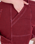 Close up of Ashley's hand in the front pocket of Railroad Carpenter Shorts in Mustang Red
