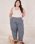 Ashley is 5'7" and wearing 1XL Denim Trouser Jeans in Railroad Stripe paired with Tank Top in  vintage tee off-white