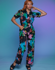 Tiara is 5'4" and wearing S Short Sleeve Jumpsuit in Rainbow Magic Waters