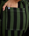 Close up of Tiara's hand in the back pocket of Black Stripe Work Pants in Evergreen