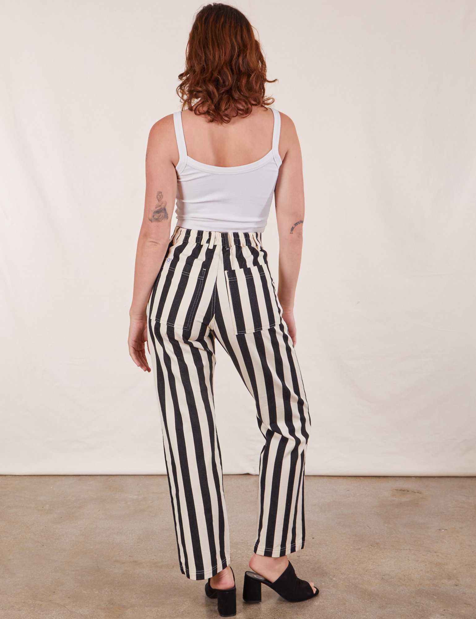 Back view of Black Striped Work Pants in White and vintage off-white Cropped Cami on Alex