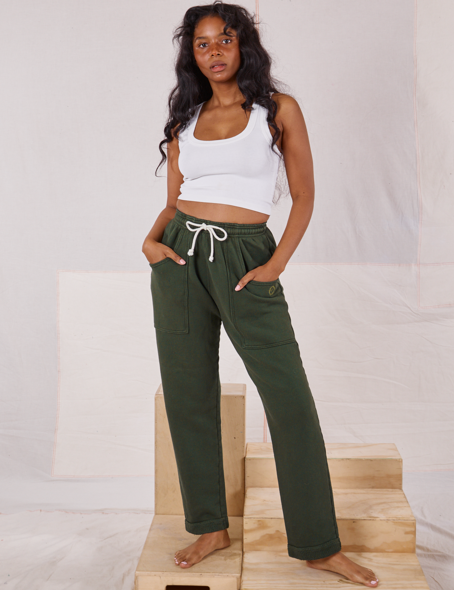 Kandia is 5&#39;3&quot; and wearing P Rolled Cuff Sweat Pants in Swamp Green paired with vintage off-white Cropped Tank Top