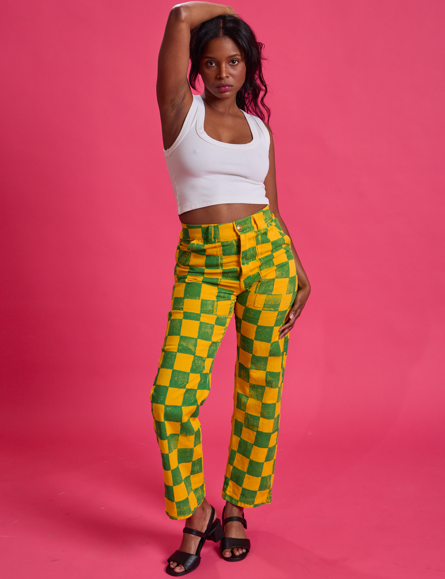 Kandia is 5'3" and wearing XS Checkerboard Work Pants in Green/Yellow paired with Cropped Tank in vintage tee white
