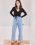 Hana is wearing Wrap Top in Basic Black and light wash Carpenter Jeans