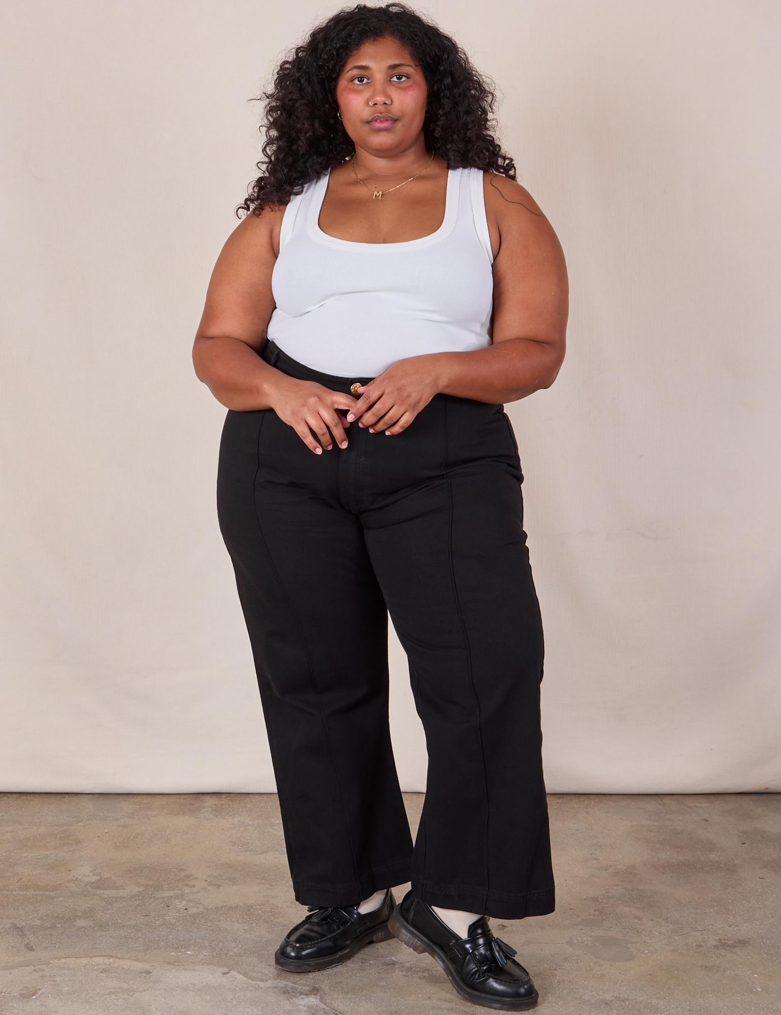 Morgan is 5'5" and wearing 2XL Western Pants in Basic Black paired with a Cropped Tank in Vintage Tee Off-White