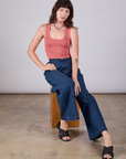 Alex is wearing Cropped Tank Top in Raspberry Sorbet and dark wash Wide Leg Denim Trousers