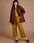 Alex is wearing Ripstop Field Coat in Fudgesicle Brown paired with spicy mustard Drop Pocket Cargo Pants