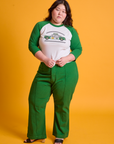 Ashley is wearing Taxi Raglan Tee in Chicago and forest green Western Pants