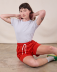 Alex is wearing Sweat Shorts in Mustang Red and stone white Jr. Varsity Tee