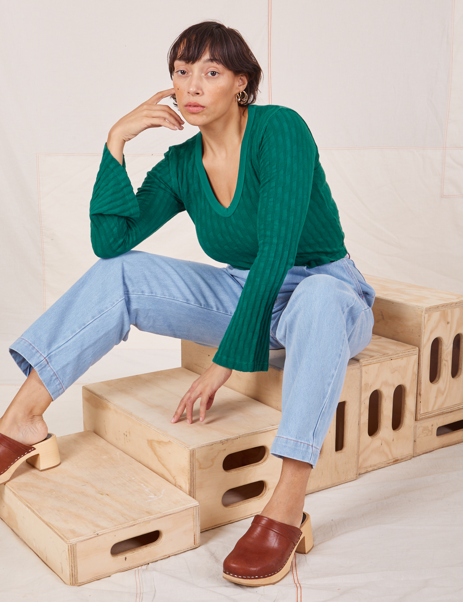 Tiara is wearing Bell Sleeve Top in Hunter Green and light wash Trouser Jeans