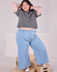 Ashley is wearing Cropped Burly Tee in Washed Grey and light wash Indigo Wide Leg Denim Trousers