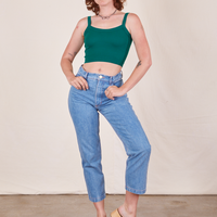 Alex is wearing Cropped Cami in Hunter Green and light wash Frontier Jeans