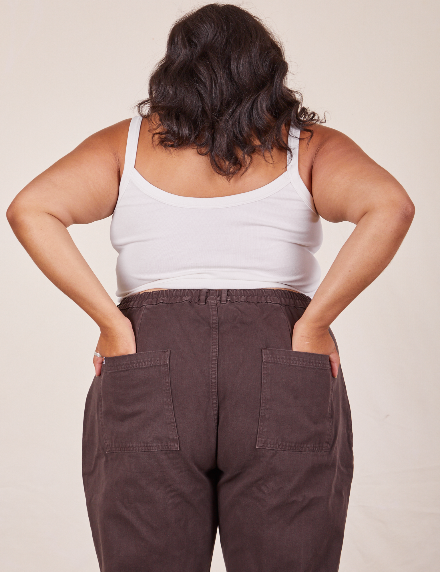 Back view of Cropped Cami in Vintage Tee Off-White and espresso brown Western Pants worn by Alicia. She has both her hands in the back pant pocket.