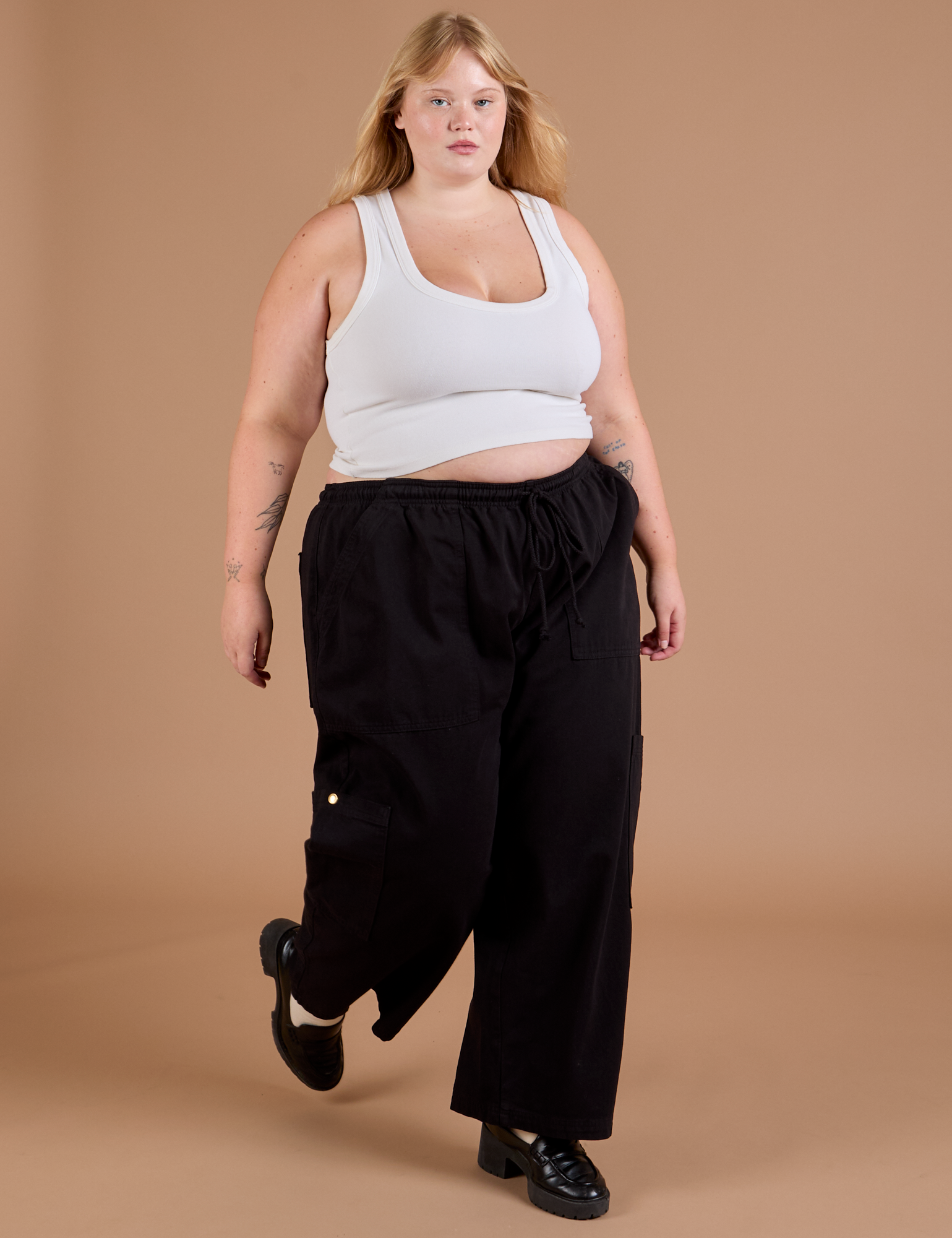 Angled front view of Drop Pocket Cargo Pants in Basic Black and Cropped Tank in vintage tee white worn by Juliet